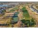Aerial view showcasing a golf course with a pond and surrounding landscape at 10632 W Roundelay Cir, Sun City, AZ 85351