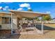 Covered patio furniture, grassy yard, and mature trees at 10632 W Roundelay Cir, Sun City, AZ 85351