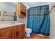 Clean bathroom with wood vanity, shower/tub combo, and tiled floor at 10632 W Roundelay Cir, Sun City, AZ 85351