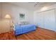 Bedroom with daybed, wood floors, and double door closet at 10632 W Roundelay Cir, Sun City, AZ 85351