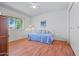 Bright bedroom features wood floors, daybed, a ceiling fan and a sunlit window at 10632 W Roundelay Cir, Sun City, AZ 85351
