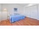 Bright bedroom with wood floors, a daybed, white closet doors, and a lamp at 10632 W Roundelay Cir, Sun City, AZ 85351