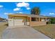 Ranch-style home with attached garage and a spacious driveway at 10632 W Roundelay Cir, Sun City, AZ 85351