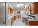 Galley kitchen with wood cabinets and tile flooring at 10632 W Roundelay Cir, Sun City, AZ 85351