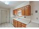 Kitchen with wood cabinets, double sink, and a window overlooking the backyard at 10632 W Roundelay Cir, Sun City, AZ 85351