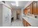 Kitchen with wood cabinets, white appliances, and tile floors at 10632 W Roundelay Cir, Sun City, AZ 85351