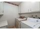 Laundry room with washer, dryer, and overhead cabinets at 10632 W Roundelay Cir, Sun City, AZ 85351
