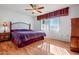 Main bedroom with king-size bed, wood floors, and ceiling fan at 10632 W Roundelay Cir, Sun City, AZ 85351