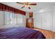 Main bedroom with king-size bed, wood floors, and ceiling fan at 10632 W Roundelay Cir, Sun City, AZ 85351