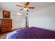 Main bedroom with king-size bed, wood floors, and ceiling fan at 10632 W Roundelay Cir, Sun City, AZ 85351