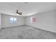 Spacious bedroom with ceiling fan and neutral carpeting at 11120 E Grove St, Mesa, AZ 85208