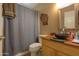 Bathroom with wood vanity, vessel sink, and shower/tub combo at 11865 N Allegro Rd, Maricopa, AZ 85139