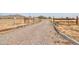 Gravel driveway leading to a ranch style home with wooden gates at 11865 N Allegro Rd, Maricopa, AZ 85139