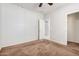 Well-lit bedroom with carpet flooring and access to a bathroom and closet at 1727 N 213Th Dr, Buckeye, AZ 85396