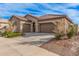 Two-car garage, tan exterior, and nicely landscaped front yard at 1727 N 213Th Dr, Buckeye, AZ 85396