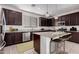 Beautiful kitchen featuring dark cabinets, stainless steel appliances, and an island with granite countertops at 1727 N 213Th Dr, Buckeye, AZ 85396