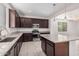 Modern kitchen features granite countertops and dark brown cabinets at 1727 N 213Th Dr, Buckeye, AZ 85396