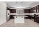 Kitchen with dark wood cabinets, granite countertops, and an island at 1727 N 213Th Dr, Buckeye, AZ 85396