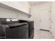 Laundry room with LG washer and dryer and overhead shelving at 1727 N 213Th Dr, Buckeye, AZ 85396