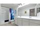 Bathroom with double sinks, shower, and blue accents at 18225 W Foothill Dr, Surprise, AZ 85387