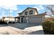 Two-story house with gray siding, a three-car garage, and a landscaped front yard at 18225 W Foothill Dr, Surprise, AZ 85387