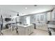 Open kitchen with white cabinets, island, and view into living room at 18225 W Foothill Dr, Surprise, AZ 85387