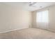 Bright bedroom with carpeted floor, ceiling fan, and window coverings at 26180 W Firehawk Dr, Buckeye, AZ 85396