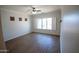 Bright bedroom with wood-look floors, window shutters, and a ceiling fan at 3410 N 131St Ln, Litchfield Park, AZ 85340