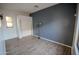Bedroom with wood-look floors, a large window, and a gray accent wall at 3410 N 131St Ln, Litchfield Park, AZ 85340
