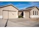 Tan house with a two-car garage and a long driveway at 3410 N 131St Ln, Litchfield Park, AZ 85340