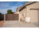 Side yard with a wooden gate and part of the garage at 3410 N 131St Ln, Litchfield Park, AZ 85340