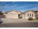 Tan house with a three-car garage and desert landscaping at 3410 N 131St Ln, Litchfield Park, AZ 85340