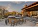 Outdoor kitchen, fireplace, and seating area create a relaxing backyard oasis at 38450 N 95Th Way, Scottsdale, AZ 85262