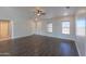 Bright living room with dark laminate flooring, high ceilings, and ceiling fan at 50011 W Mayer Blvd, Maricopa, AZ 85139