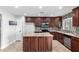 Kitchen with island, dark wood cabinets and granite countertops at 5674 S 237Th Dr, Buckeye, AZ 85326