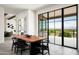 Bright dining area with wooden table and black chairs, showcasing stunning views through large windows at 5939 E Quartz Mountain Rd, Paradise Valley, AZ 85253