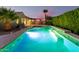 Long rectangular pool with waterfall feature and a lush hedge at 808 W Brangus Way, San Tan Valley, AZ 85143