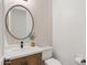 Clean bathroom with a contemporary vanity and circular mirror at 8500 E Aster Dr, Scottsdale, AZ 85260