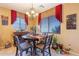 Charming dining area with dark wood table and red curtains at 16140 W Almeria Rd, Goodyear, AZ 85395