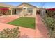 Landscaped backyard with artificial turf and a covered patio at 16530 N 114Th Dr, Surprise, AZ 85378
