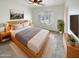 Spacious main bedroom with wood platform bed and large window with shutters at 16530 N 114Th Dr, Surprise, AZ 85378