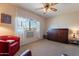 Living room with red chairs, ceiling fan, and wood cabinet at 18801 N Kiva Dr, Sun City, AZ 85373