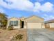 Tan house with two-car garage and desert landscaping at 41096 W Jenna Ln, Maricopa, AZ 85138