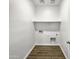 Simple laundry room with tile flooring and shelving at 41096 W Jenna Ln, Maricopa, AZ 85138