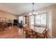 Dining area with wood floors, glass table, and adjacent living room at 6413 W Irma Ln, Glendale, AZ 85308