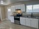 Bright kitchen features modern appliances, granite countertops, and white cabinets with door to outside at 8323 W Devonshire Ave, Phoenix, AZ 85037