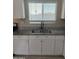 A double stainless steel sink with granite countertop is surrounded by white cabinets at 8323 W Devonshire Ave, Phoenix, AZ 85037