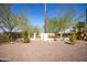 Backyard with gravel, trees, and a block fence at 11034 W Alabama Ave, Sun City, AZ 85351