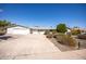 Ranch style home with a large driveway and mature shrubs at 11034 W Alabama Ave, Sun City, AZ 85351