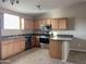 Modern kitchen with wood cabinets, granite countertops, and stainless steel appliances at 14819 N Mauna Loa Ln, Phoenix, AZ 85053